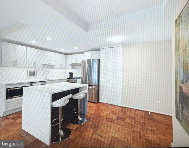 a kitchen with stainless steel appliances granite countertop a refrigerator sink and white cabinets