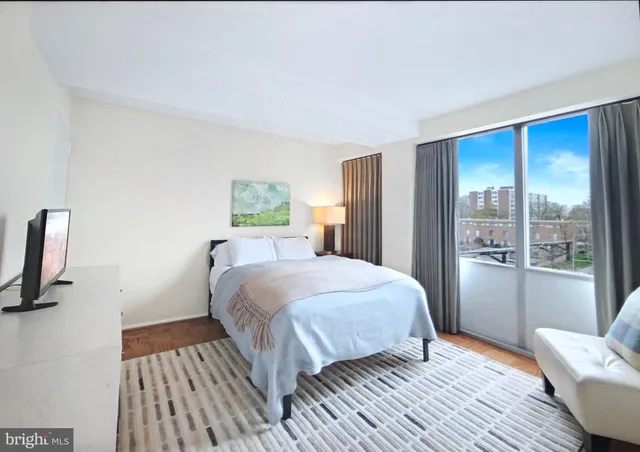 a bedroom with a bed wooden floor and window