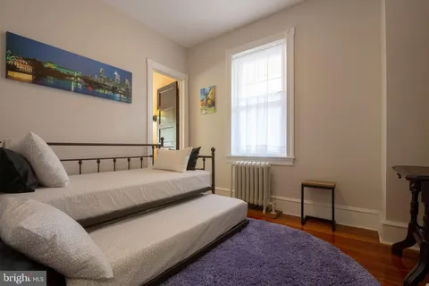 a bed sitting in a bedroom next to a window