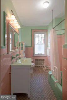 a bathroom with a granite countertop sink a toilet a mirror and shower