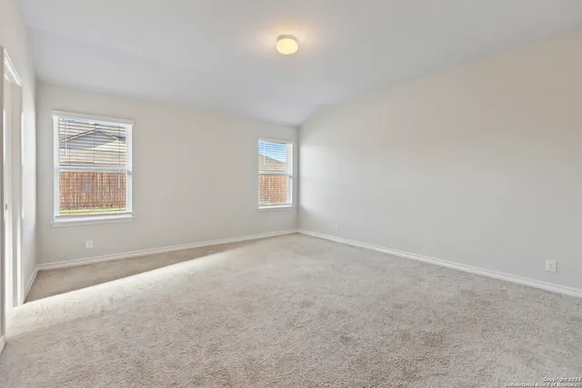 an empty room with windows and closet