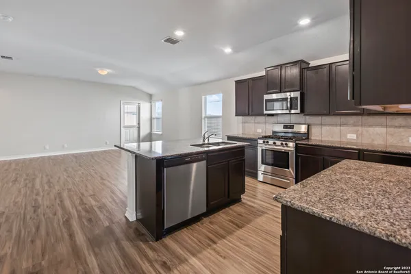 a kitchen with a stove sink and cabinets