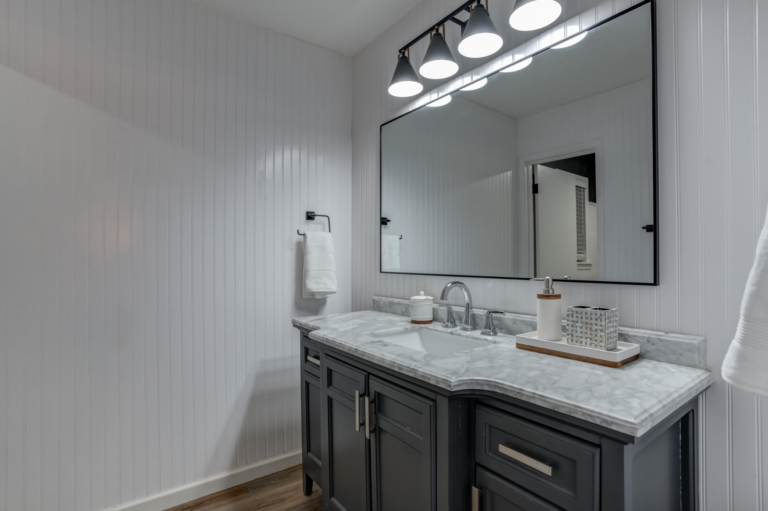 2802 39th Street Lubbock, TX 79413 - Photo 39 of 61 a bathroom with a granite countertop sink a light fixture and a mirror