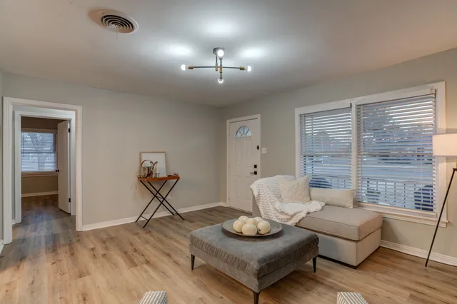 a living room with furniture and a wooden floor