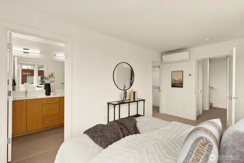 a bedroom with a bed a mirror and lamp