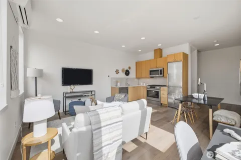 a living room with furniture a flat screen tv and a view of kitchen