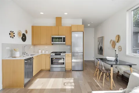 a kitchen with granite countertop a stove a sink and a refrigerator