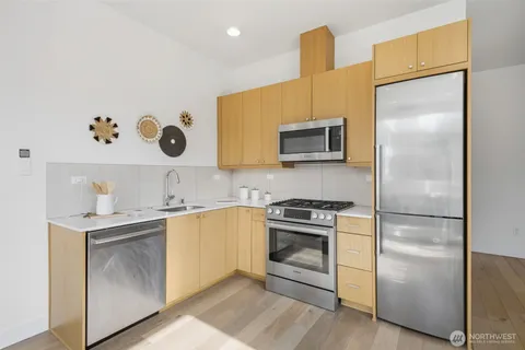 a kitchen with a sink a refrigerator and a stove top oven