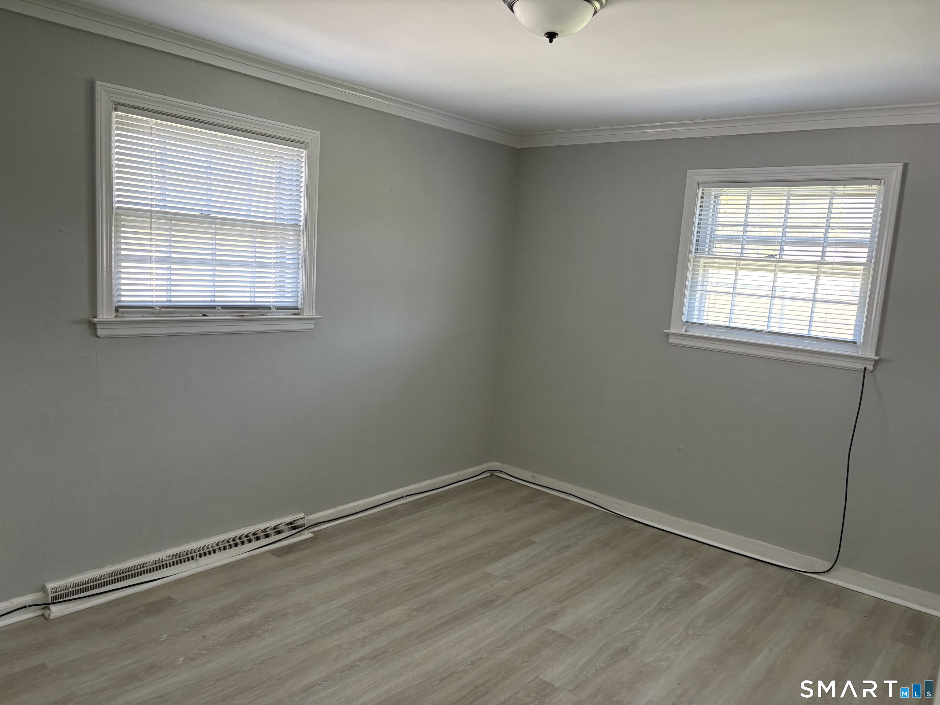 832 Milford Point Road Milford, CT 06460 - Photo 4 of 11 an empty room with wooden floor and windows