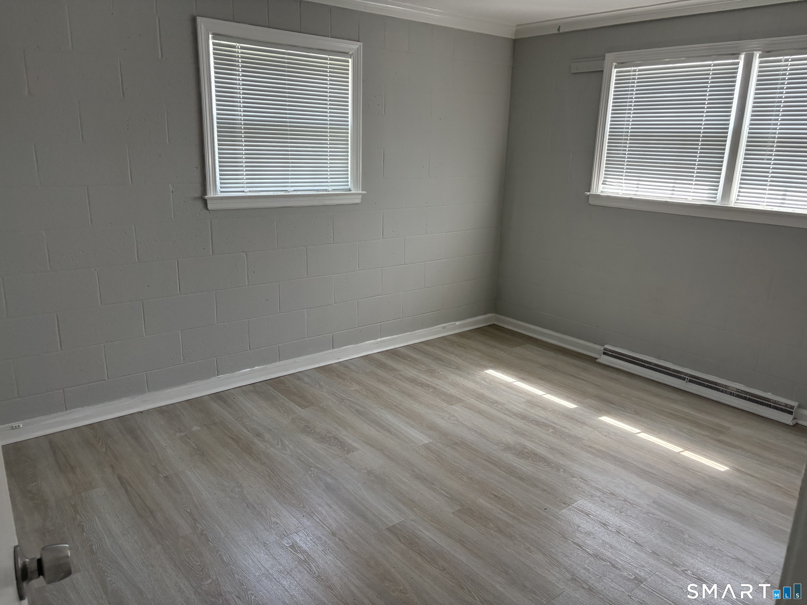 832 Milford Point Road Milford, CT 06460 - Photo 5 of 11 an empty room with wooden floor and windows