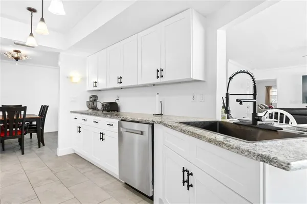 a kitchen with granite countertop white cabinets and white appliances