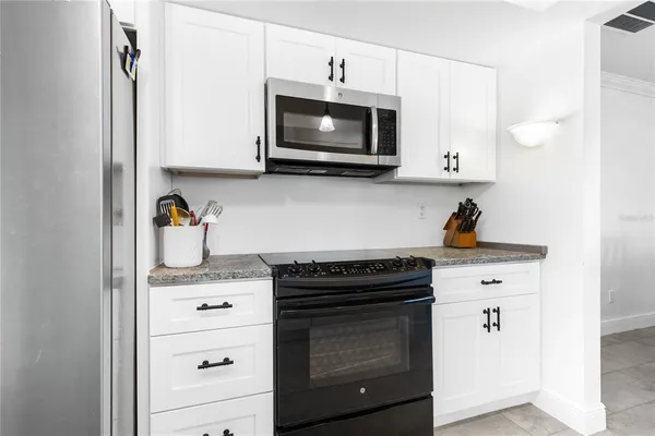 a kitchen with stainless steel appliances granite countertop a stove a microwave and cabinets