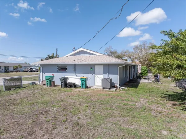 a view of a house with a patio and a yard