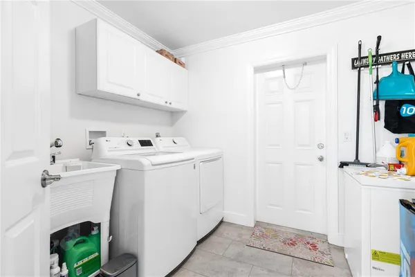 a utility room with cabinets washer and dryer
