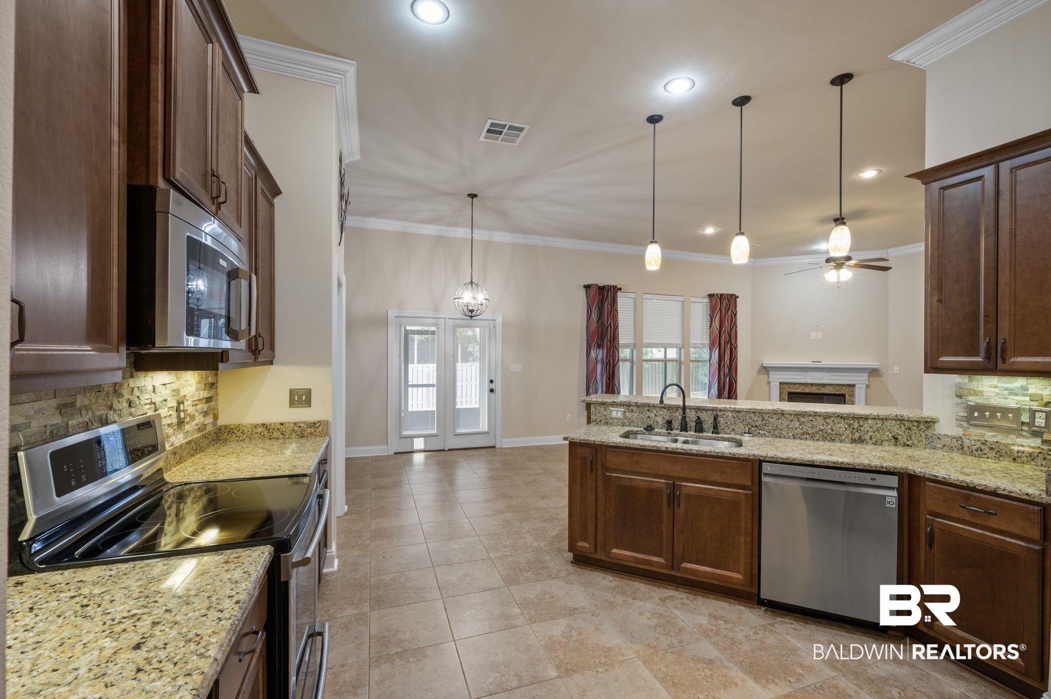 1085 Destin Avenue Foley, AL 36535 - Photo 9 of 35 Kitchen featuring sink, hanging light fixtures, appliances with stainless steel finishes, kitchen peninsula, and decorative backsplash