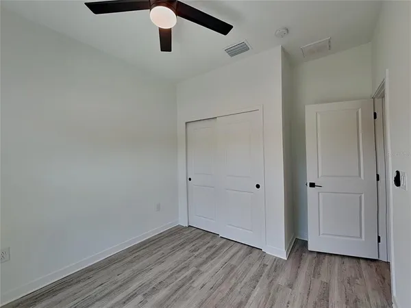 a view of an empty room with wooden floor