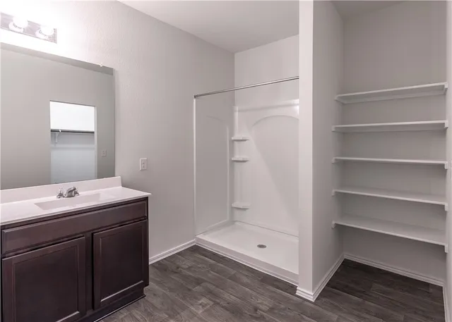 a bathroom with a shower sink and mirror