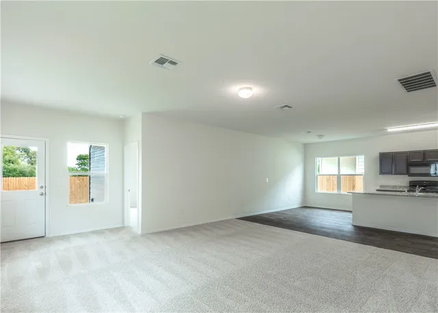 a view of a kitchen and a windows in an empty room