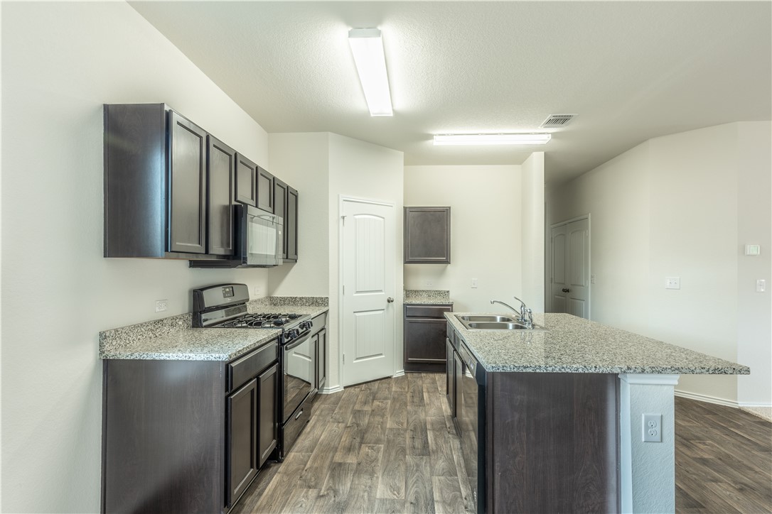15204 Kent Justin Austin, TX 78725 - Photo 8 of 22 a kitchen with a sink stove and refrigerator