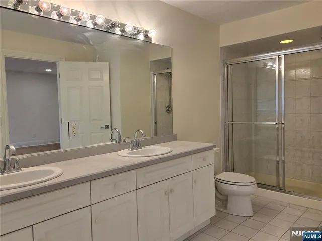 a bathroom with a double vanity sink toilet and a mirror