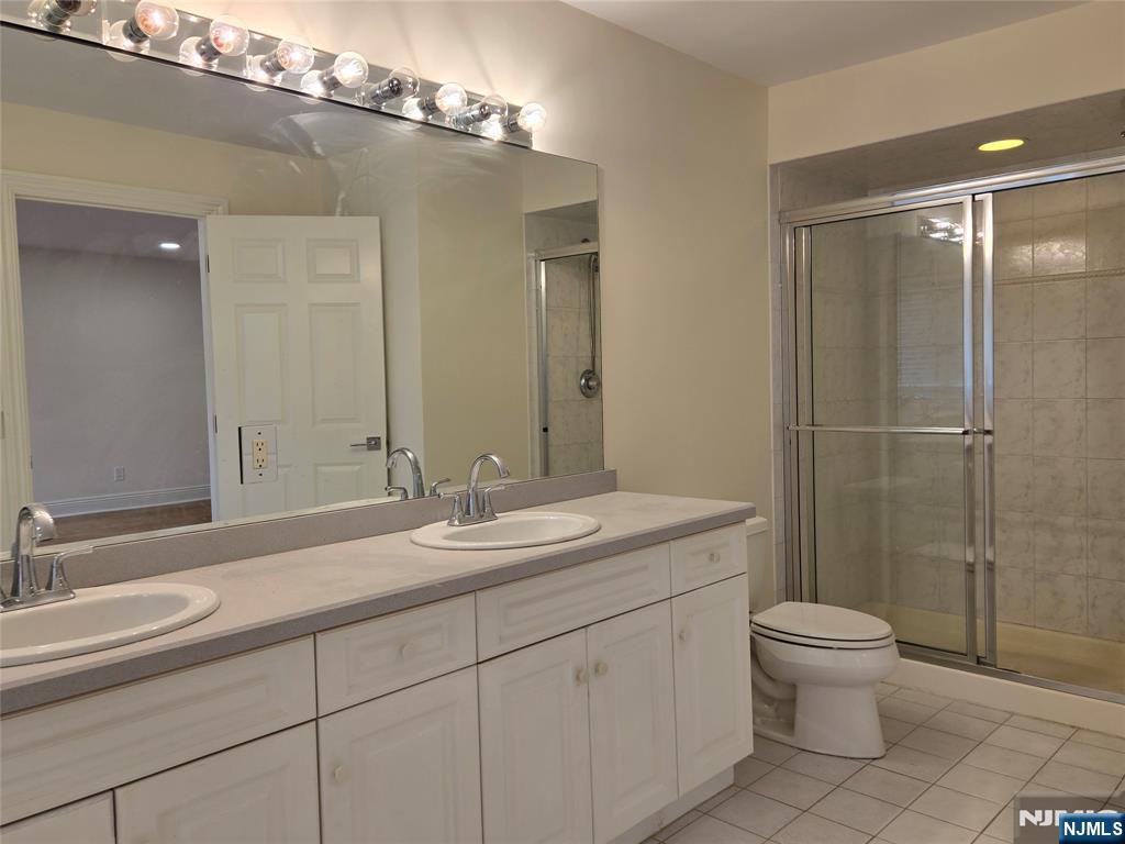 139 Stonegate Trail, Unit 40 Cresskill, NJ 07626 - Photo 16 of 23 a bathroom with a double vanity sink toilet and a mirror