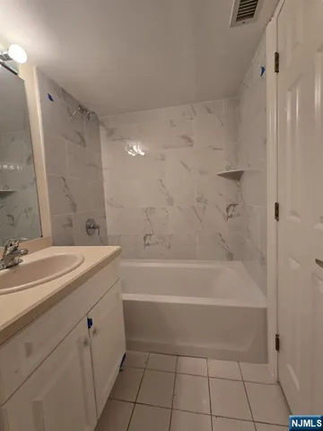 a bathroom with a bathtub a sink a vanity and a shower