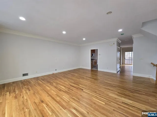 a view of empty room with wooden floor