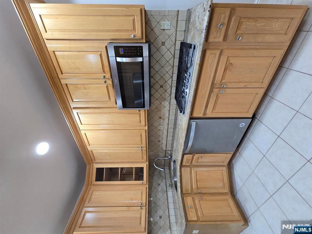 139 Stonegate Trail, Unit 40 Cresskill, NJ 07626 - Photo 8 of 23 a kitchen with granite countertop cabinets stainless steel appliances a sink and a large window