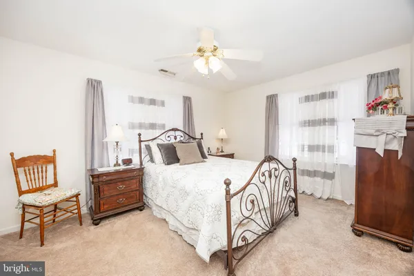 a spacious bedroom with a bed and a chandelier