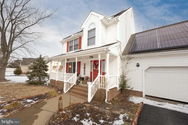 a view of a white house with large windows and a road