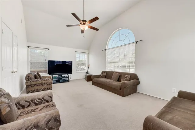 a living room with furniture a flat screen tv and a window