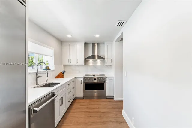 a kitchen with granite countertop white cabinets and stainless steel appliances