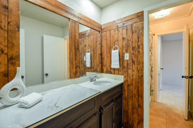a bathroom with a granite countertop sink and a mirror