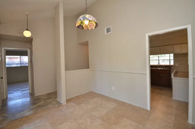 an empty room with kitchen and windows