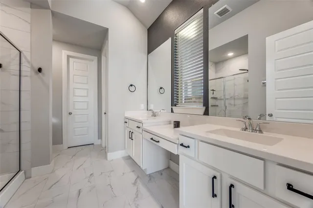 a spacious bathroom with a double vanity sink mirror and shower