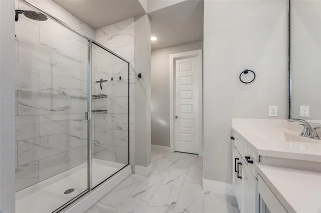 a bathroom with a shower sink and mirror