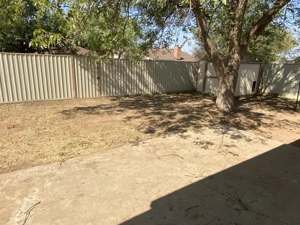 a view of a yard with wooden fence
