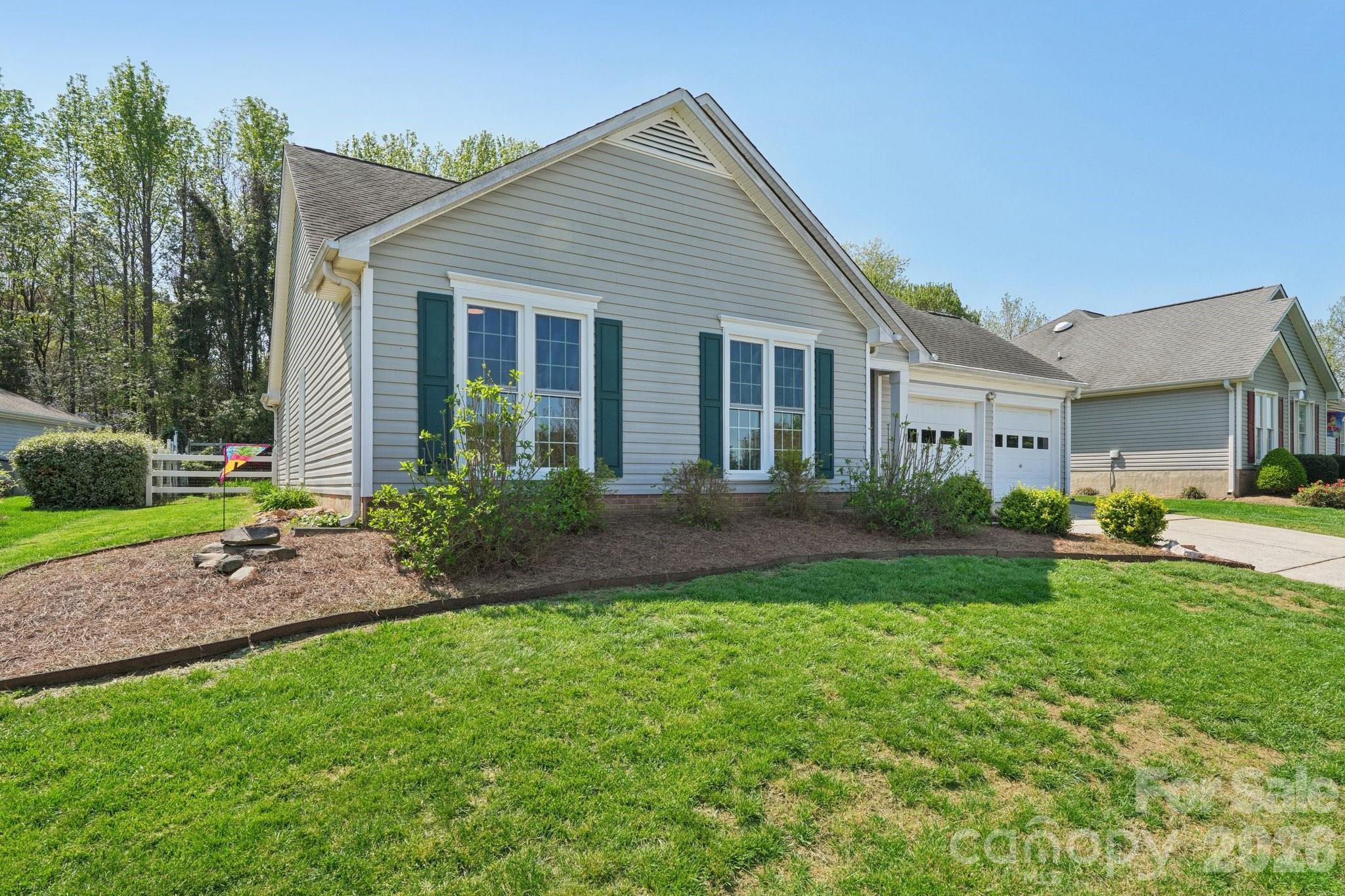 3661 Lake Spring Avenue Northwest Concord, NC 28027 - Photo 2 of 42 a front view of a house with a garden and porch