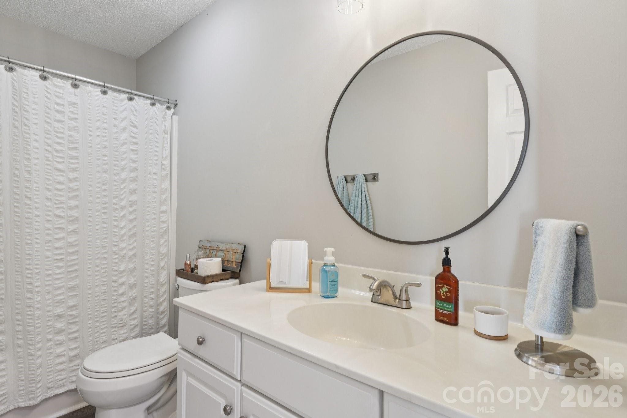3661 Lake Spring Avenue Northwest Concord, NC 28027 - Photo 27 of 42 a bathroom with a sink a toilet and a mirror