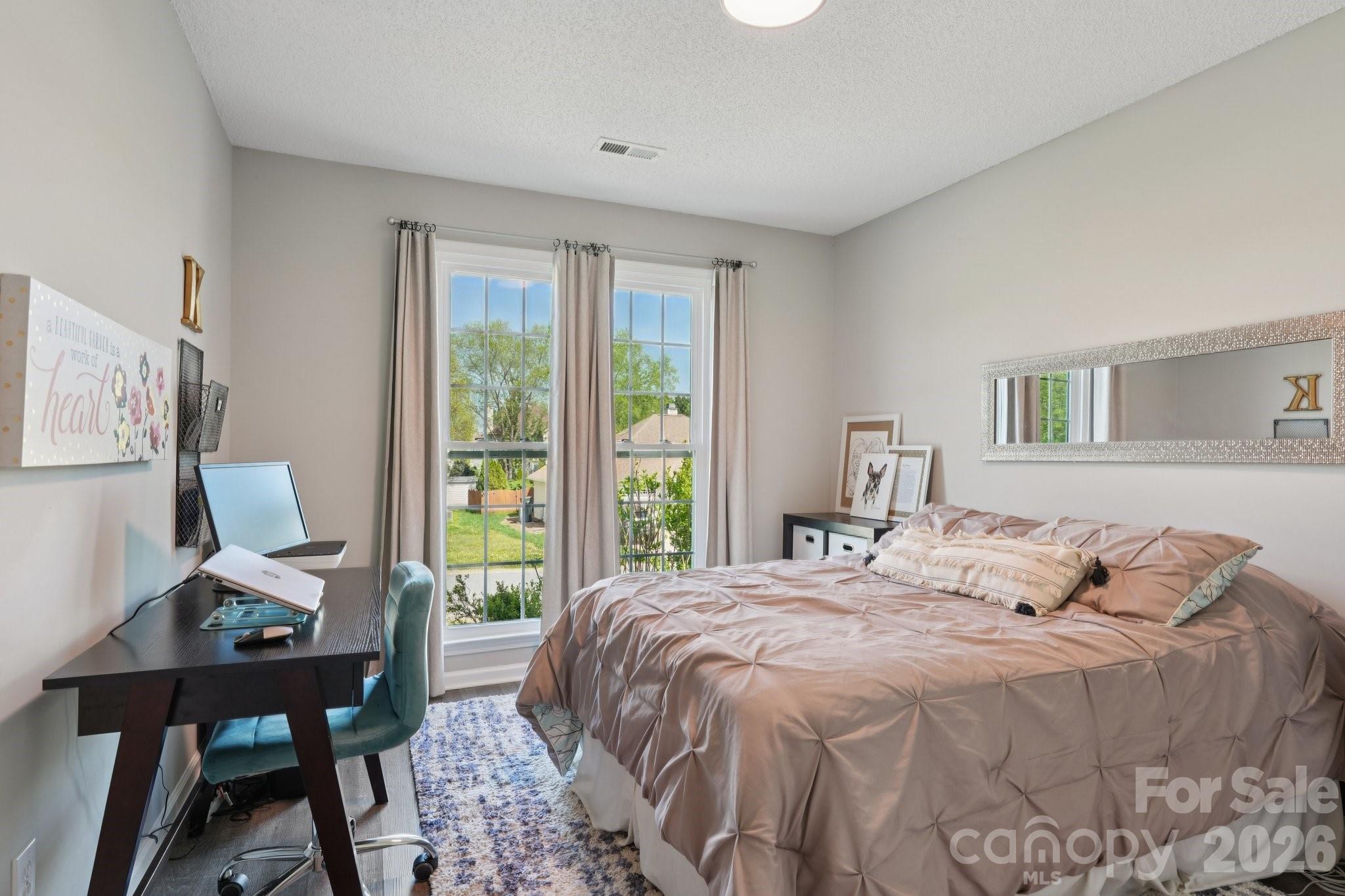3661 Lake Spring Avenue Northwest Concord, NC 28027 - Photo 28 of 42 a bedroom with a bed a table and a window