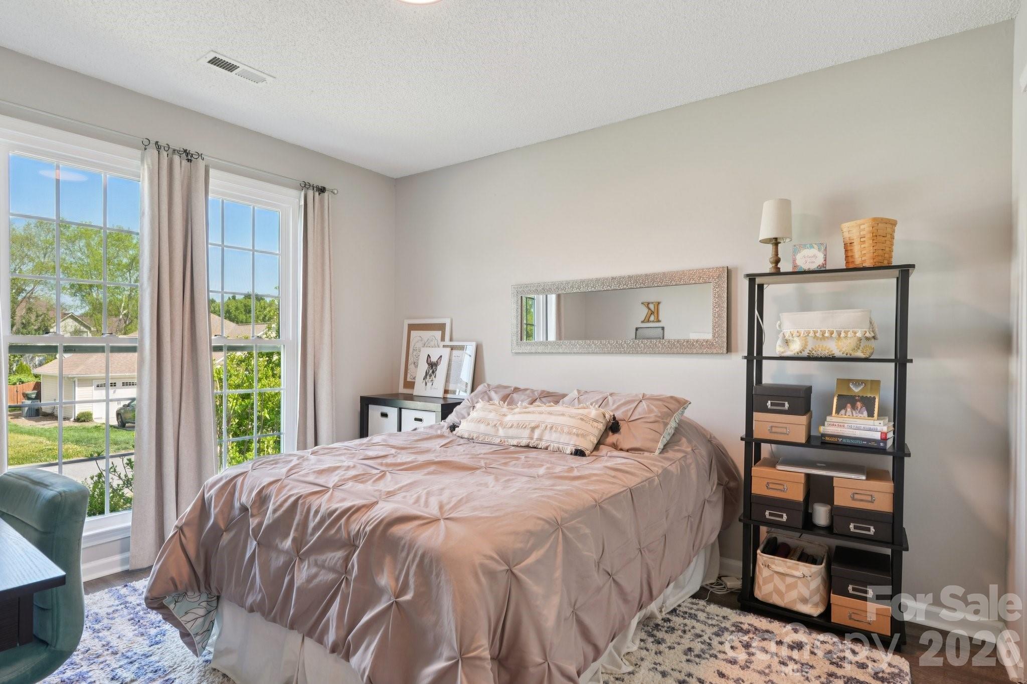 3661 Lake Spring Avenue Northwest Concord, NC 28027 - Photo 29 of 42 a bedroom with a bed a table and a large window