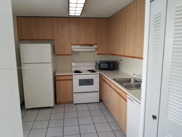 a kitchen with a stove top oven and cabinets
