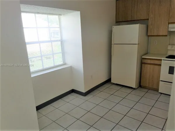 a view of a kitchen with white cabinets