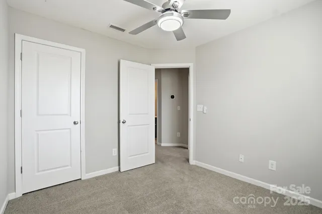 an empty room with a ceiling fan and a window