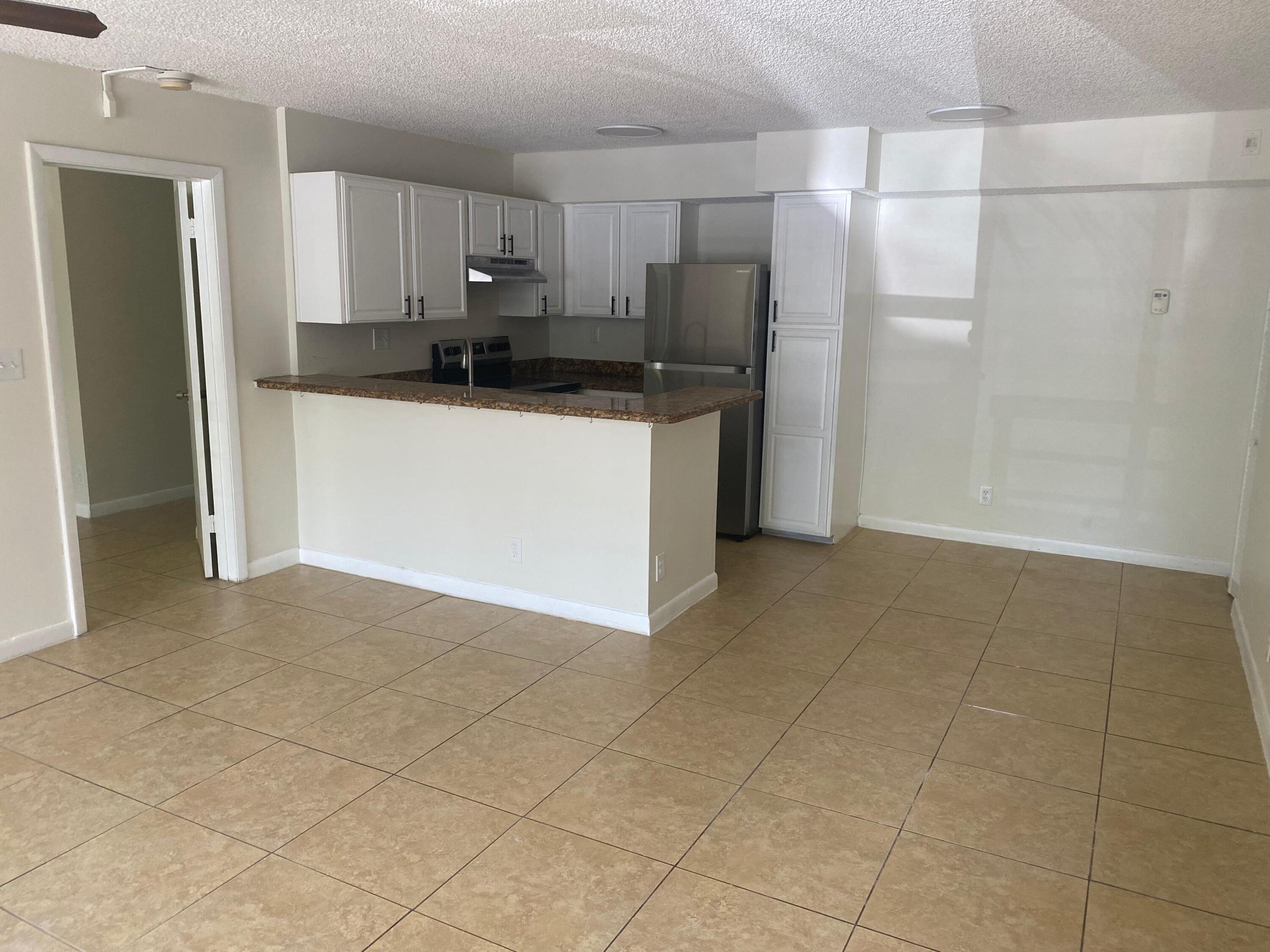 601 Lyons Road, Unit 7105 Coconut Creek, FL 33063 - Photo 3 of 13 a kitchen with stainless steel appliances granite countertop a refrigerator sink and cabinets