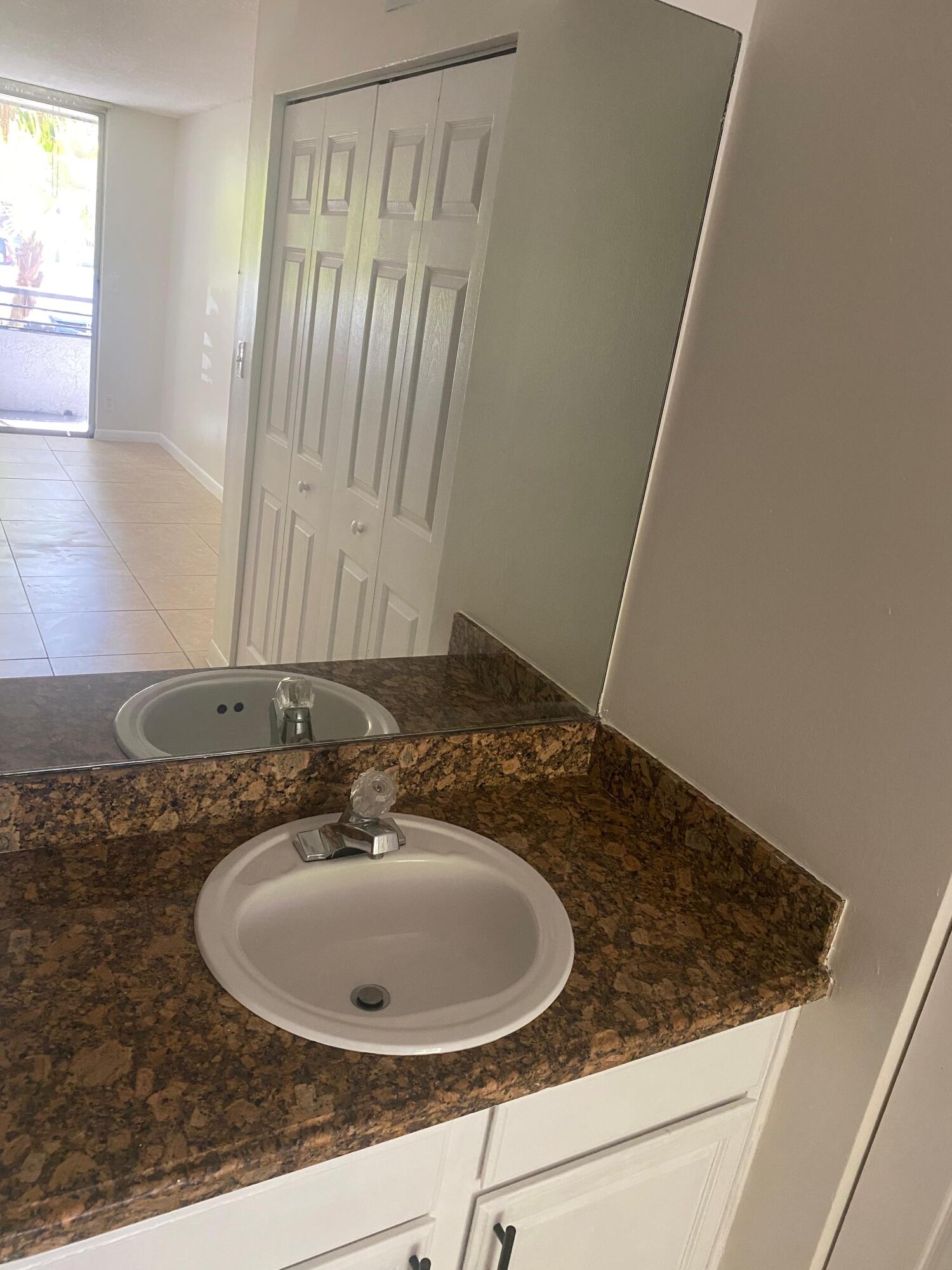 601 Lyons Road, Unit 7105 Coconut Creek, FL 33063 - Photo 7 of 13 a bathroom with a granite countertop sink and a mirror