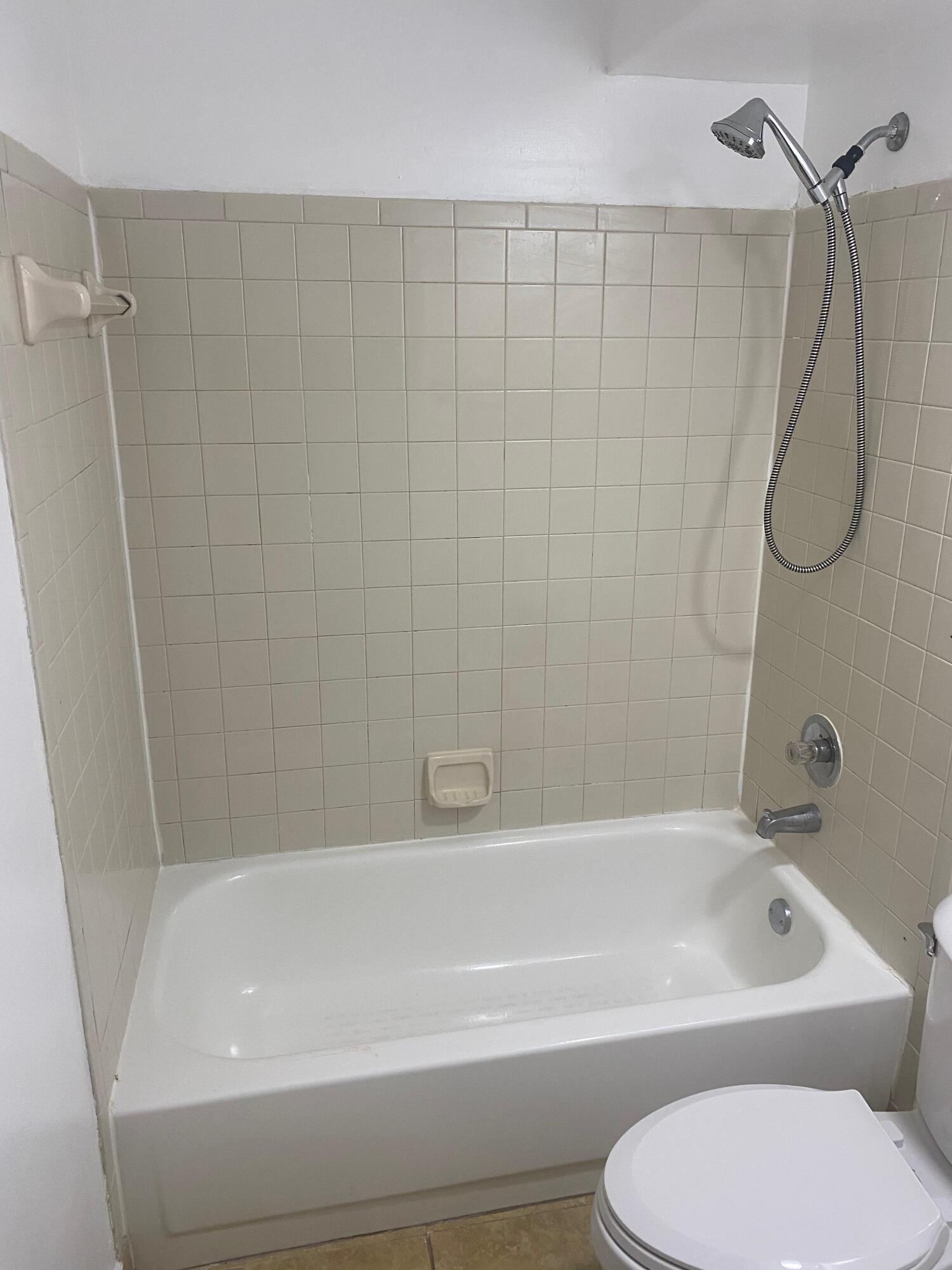 601 Lyons Road, Unit 7105 Coconut Creek, FL 33063 - Photo 8 of 13 a bathroom with a toilet and a bath tub