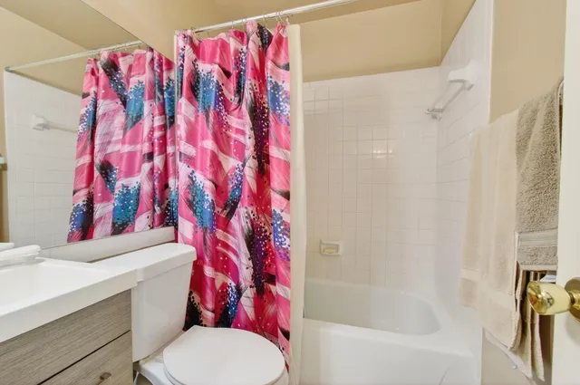 a white toilet sitting next to a bath tub