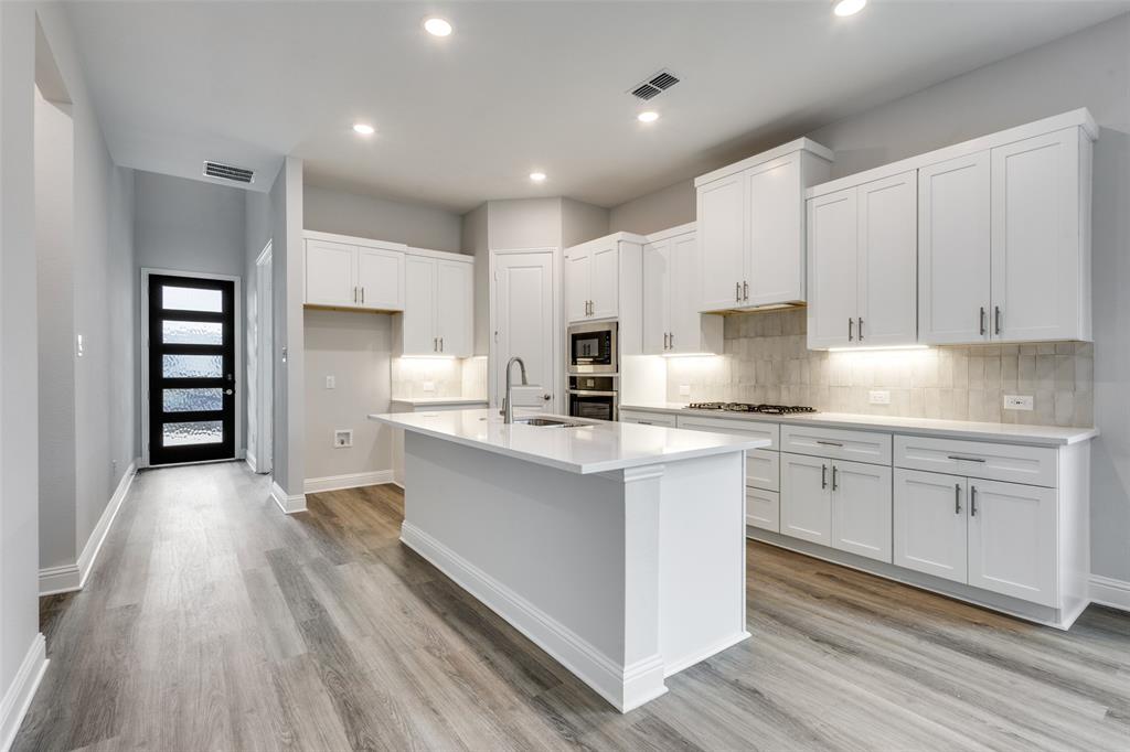 11764 Chartwell Court Frisco, TX 75035 - Photo 6 of 25 a kitchen with kitchen island granite countertop a sink cabinets and stainless steel appliances