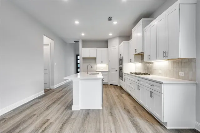 a kitchen with granite countertop white cabinets and white appliances
